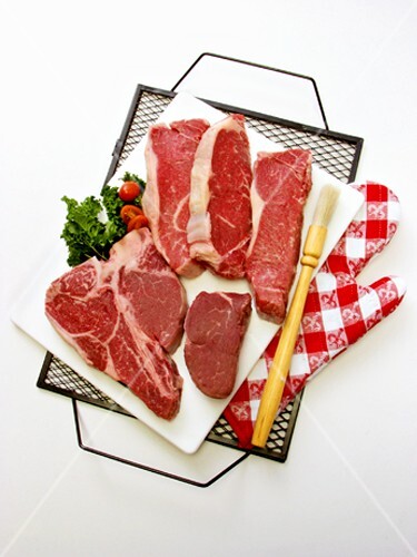 Beef steaks with barbecue utensils