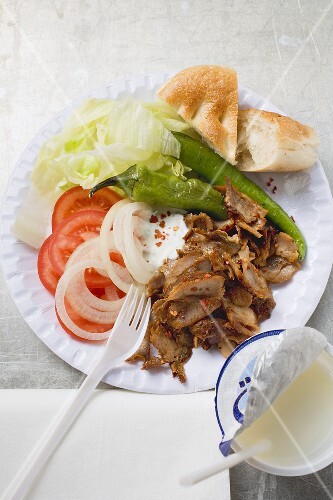 Döner mit Gemüse auf Pappteller und Trinkjoghurt