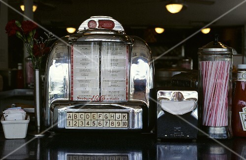 Juke box, paper napkins in dispenser and straws