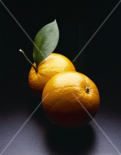 Two Whole Oranges; One with Leaf