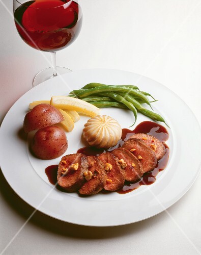 Slice Roasted Loin of Lamb with Brown Demi Glace and Walnuts; Potatoes and Vegetables