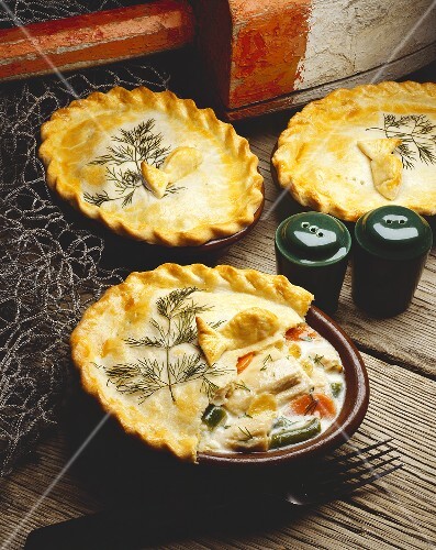 Three Tuna Pot Pies on Wooden Table; Fish Nets and Buoy