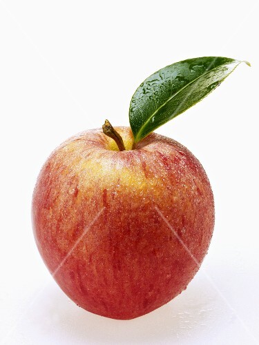Red apple with stalk, leaf and drops of water