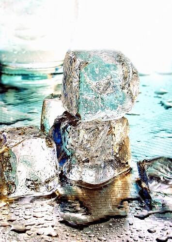Mehrere Eiswürfel vor Wasserglas