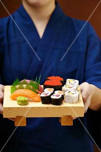 Person serviert Sushiplatte
