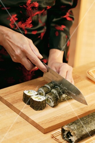Cutting rolled sushi into pieces