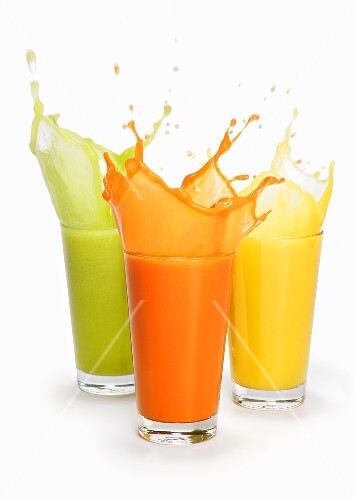 Drei spritzende Fruchtsäfte