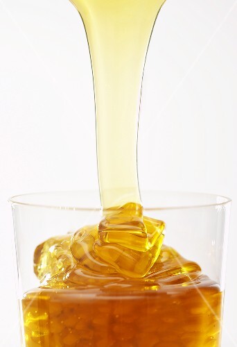 Honig fliesst in ein Glas