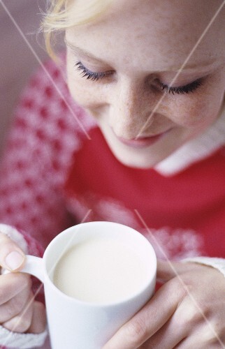 Young woman holding mug of milk