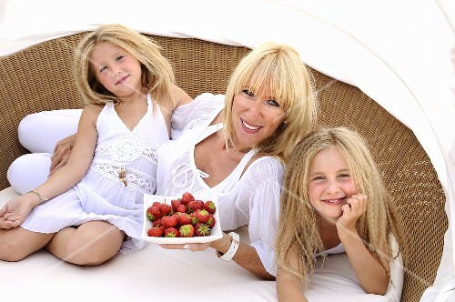 Mother and daughters with strawberries
