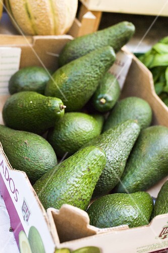 Avocados in a crate at a market