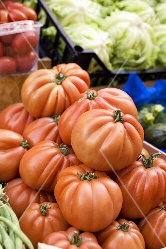 Large beefsteak tomatoes in a crate at a market
