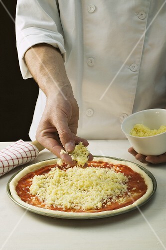 Sprinkling pizza with cheese