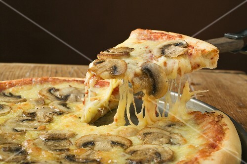 American-style mushroom pizza with piece on server