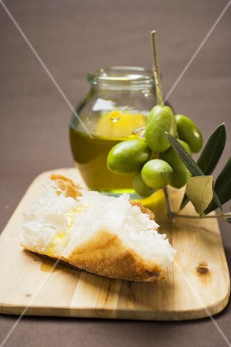 Olive sprig with green olives, white bread and olive oil