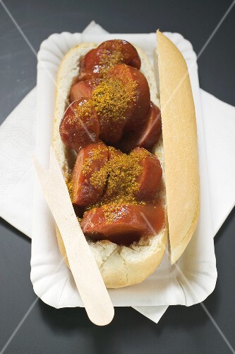 Currywurst im Brötchen auf Pappteller