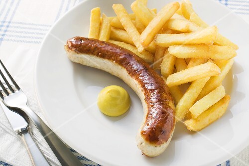Sausage with chips and mustard on plate