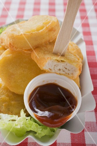 Chicken nuggets with ketchup in paper dish