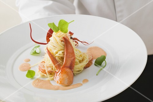 Kellner serviert Linguine mit Hummer