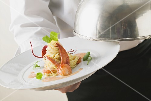 Waiter serving linguine with lobster