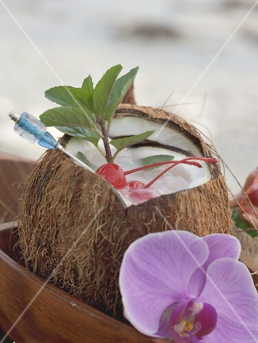 Opened coconut with mint and cocktail cherries