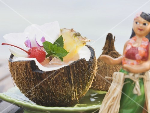 Coconut drink with pineapple, cocktail cherry and orchid