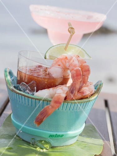Shrimps with dip, cocktail in background