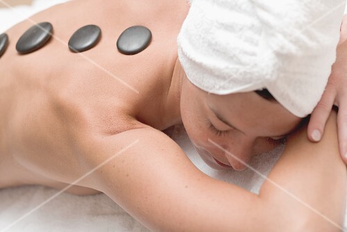 Woman having LaStone Therapy (healing therapy using stones)