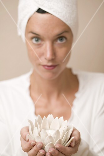 Frau hält Windlicht in Form einer Seerose