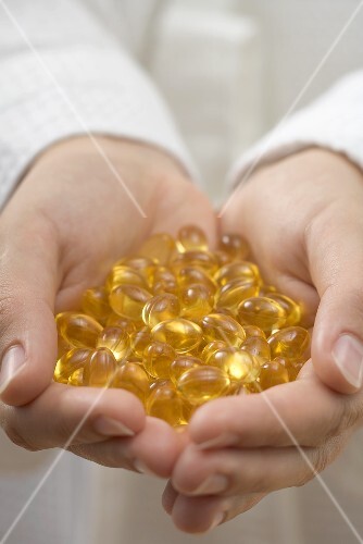 Hands holding vitamin capsules