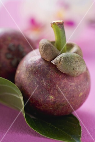 Two mangosteens with leaf