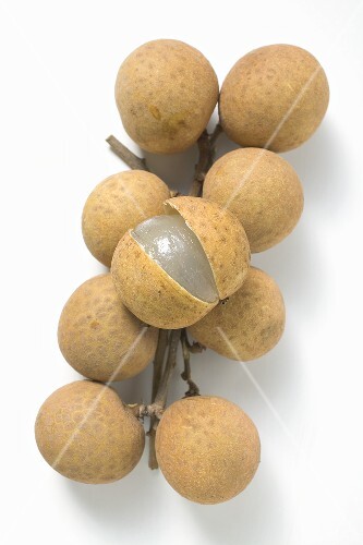 Several longans on stems, one cut open