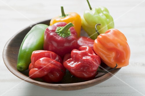 Mixed peppers and chillies in wooden dish