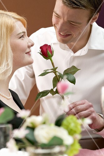 Man giving woman a red rose