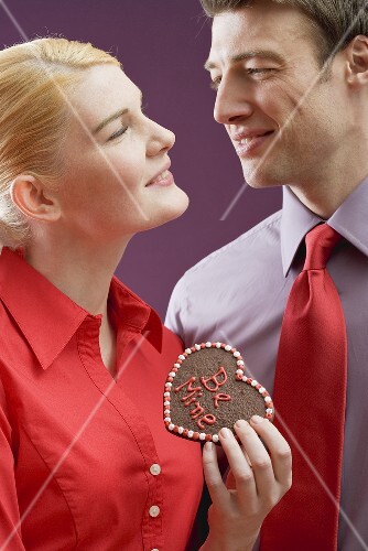 Pärchen mit Schokoladenherz mit Aufschrift Be Mine