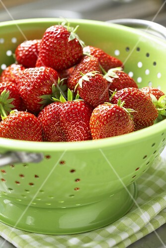 Strawberries in green colander
