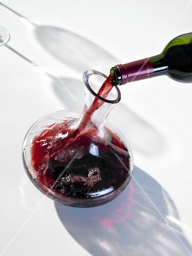 Pouring red wine into carafe