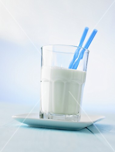 Glass of milk with two straws