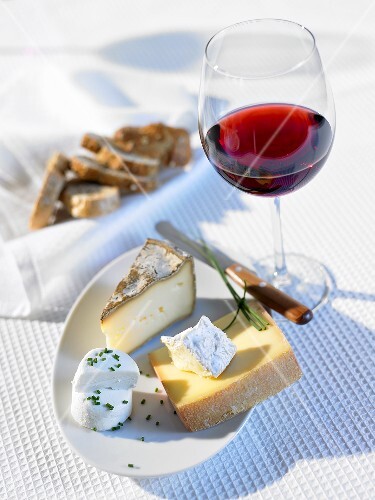 Cheese platter, glass of red wine and bread