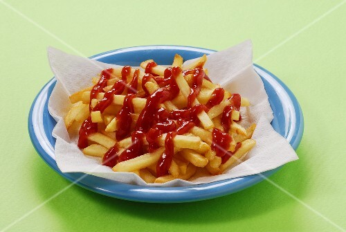 A plate of chips with a lot of ketchup