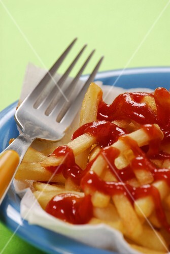 Fork lying beside chips with ketchup
