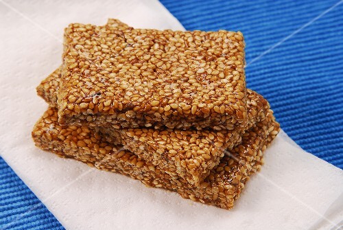 Three bars of sesame brittle lying on napkin