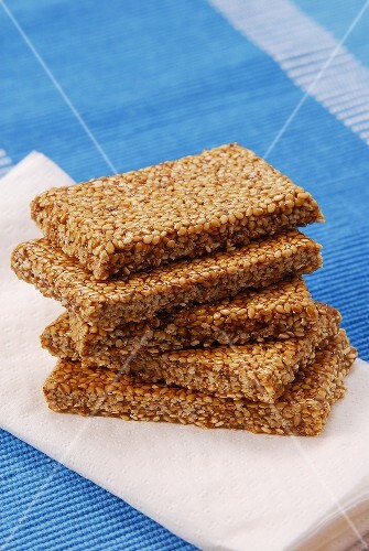 Five bars of sesame brittle, stacked, on napkin