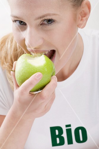 Woman eating organic green apple