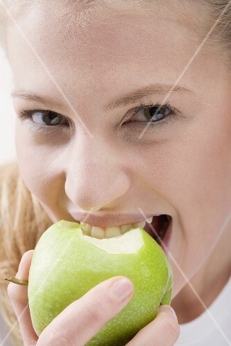 Woman eating green apple