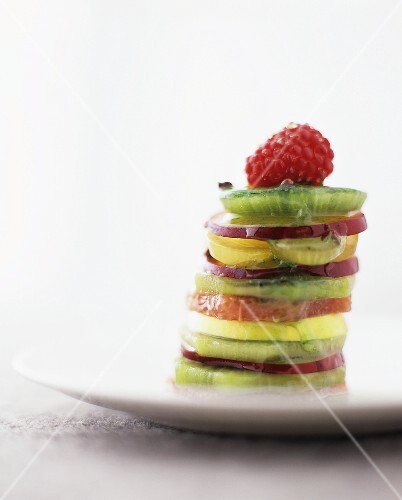 Tower of fresh fruit slices with mint and pepper sauce