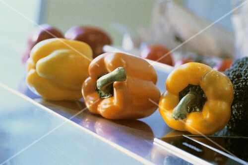 Yellow, orange and red peppers on kitchen table