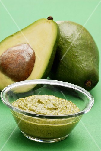Guacamole with avocados in the background