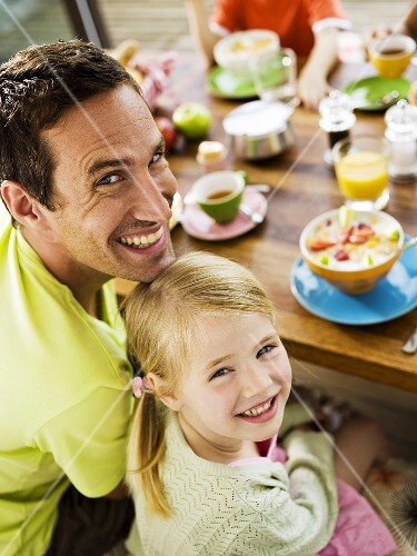 Vater und Tochter sitzen am Frühstückstisch