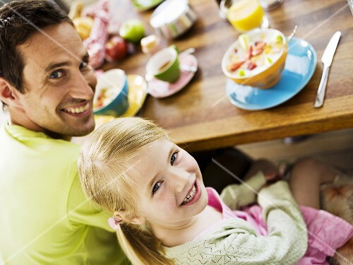 Vater und Tochter sitzen am Frühstückstisch